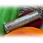 Load image into Gallery viewer, A photo of an amaranth crunch bar resting on models of cacao pods
