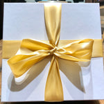 Load image into Gallery viewer, An image of a white gift box with gold ribbon
