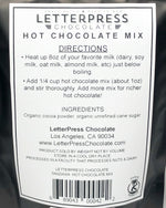 Load image into Gallery viewer, Detail photo of back of bag which reads: LetterPress Chocolate Hot Chocolate Mix, Directions: Heat up 8oz of your favorite milk (dairy, soy milk, oat milk, almond milk, etc) just below boiling. Add 1/4 cup hot chocolate mix (about 1oz) and stir thoroughly. Add more mix for richer hot chocolate! Ingredients: Organic cocoa powder, organic unrefined cane sugar.
